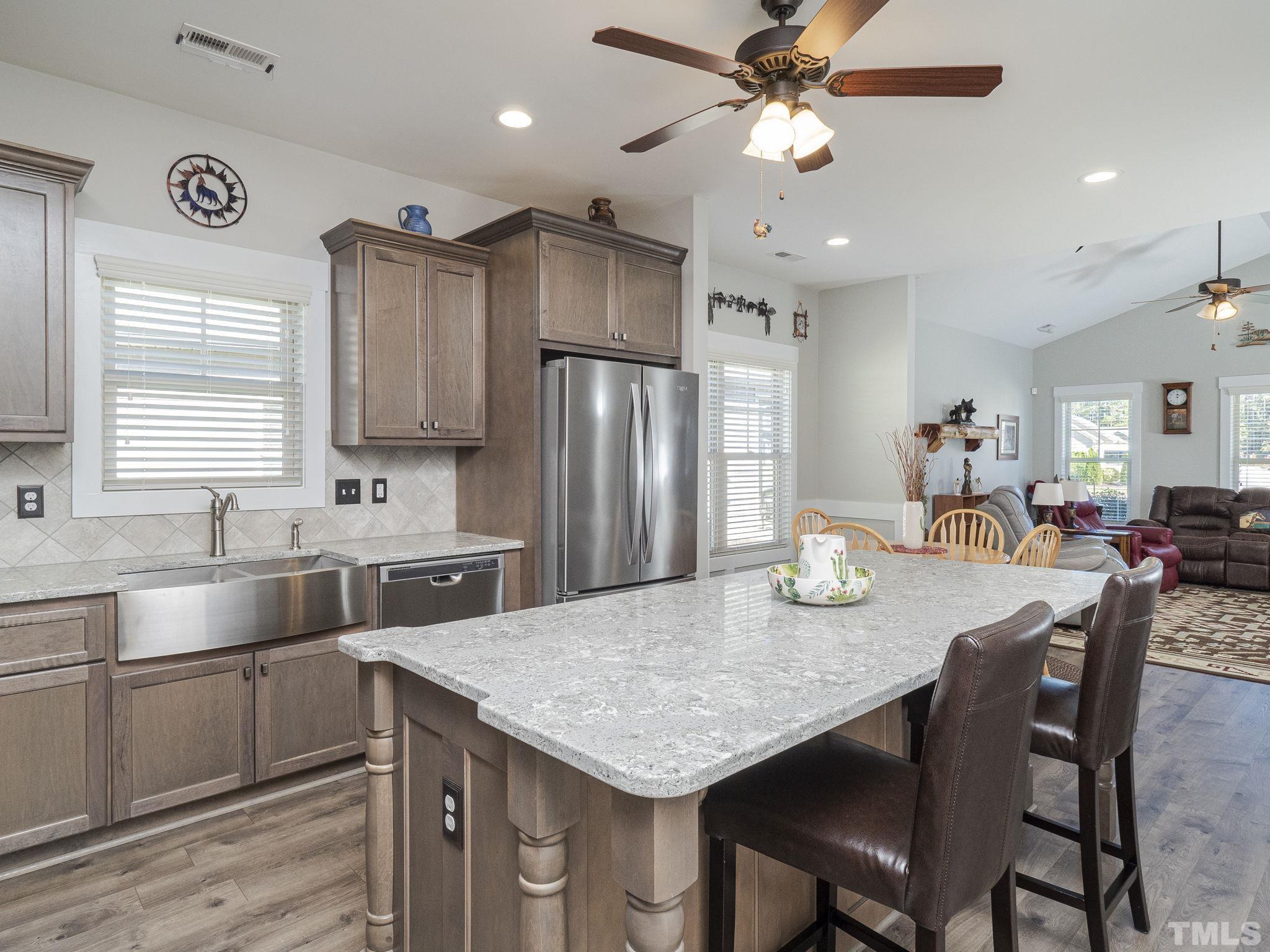 137 Bella Square Smithfield, NC 27577 - Photo 2 of 29 a kitchen with stainless steel appliances granite countertop a kitchen island a stove a table and chairs