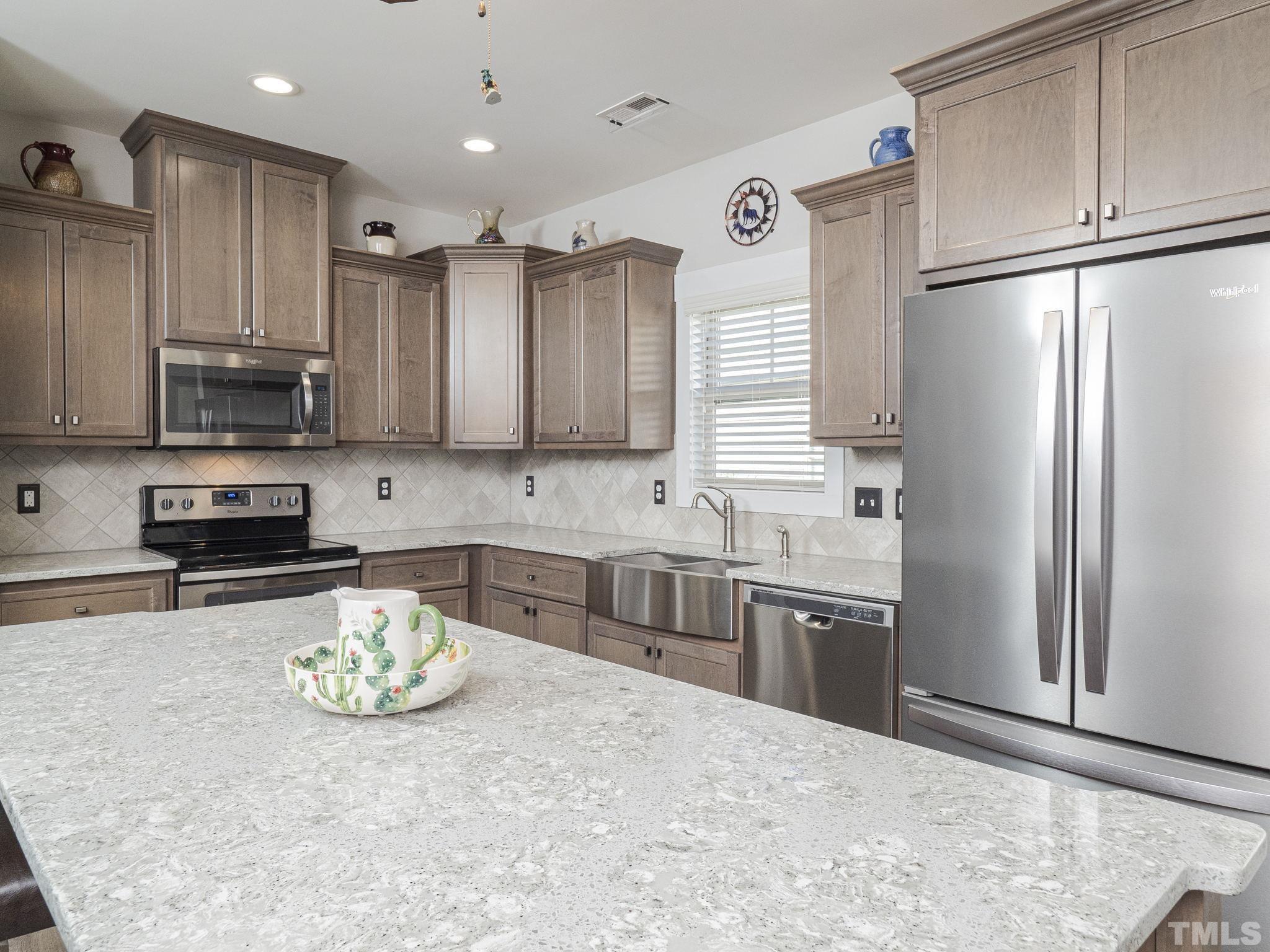 137 Bella Square Smithfield, NC 27577 - Photo 4 of 29 a kitchen with stainless steel appliances granite countertop a refrigerator sink and stove