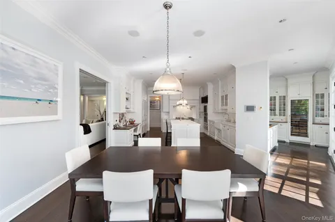 a dining room with furniture a chandelier and wooden floor
