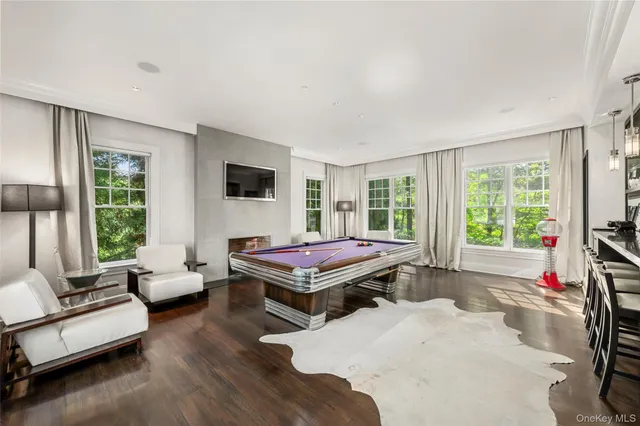 a living room with furniture a flat screen tv and a large window
