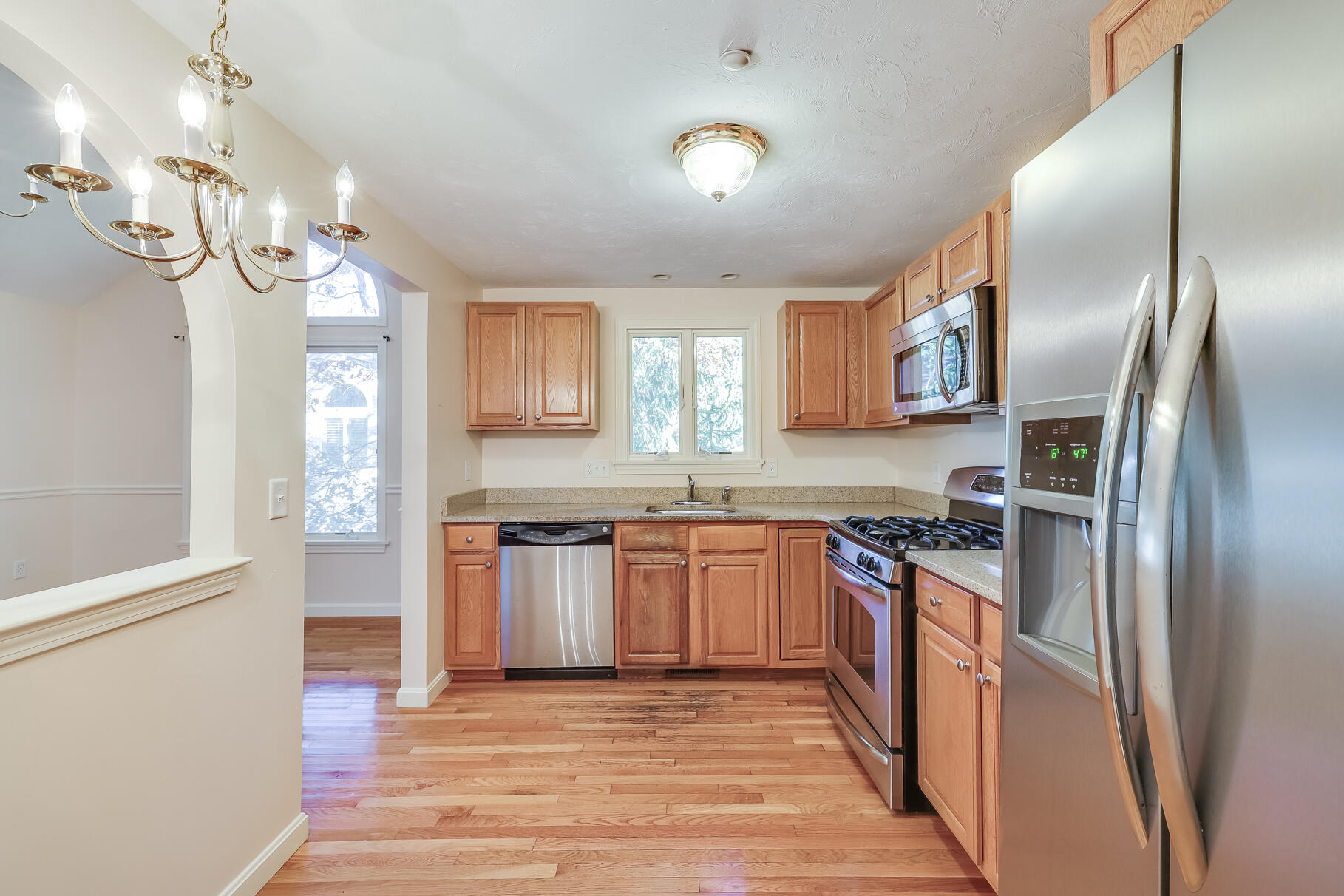 16 North Ridge Road Mashpee, MA 02649 - Photo 12 of 47 a kitchen with stainless steel appliances granite countertop a refrigerator a stove and a sink with wooden floor