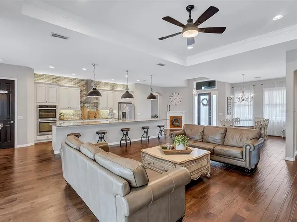 a large kitchen with stainless steel appliances granite countertop a lot of counter space a sink and dishwasher a stove top oven with wooden floor