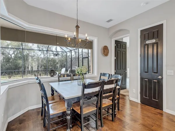a kitchen with stainless steel appliances granite countertop a kitchen island hardwood floor and chairs