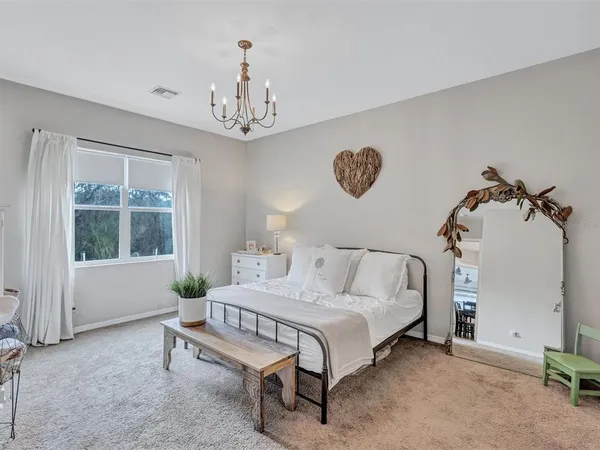 a bedroom with a bed and a chandelier