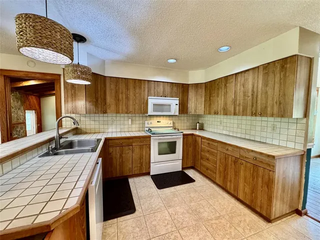 a kitchen with stainless steel appliances kitchen island granite countertop a refrigerator and a stove