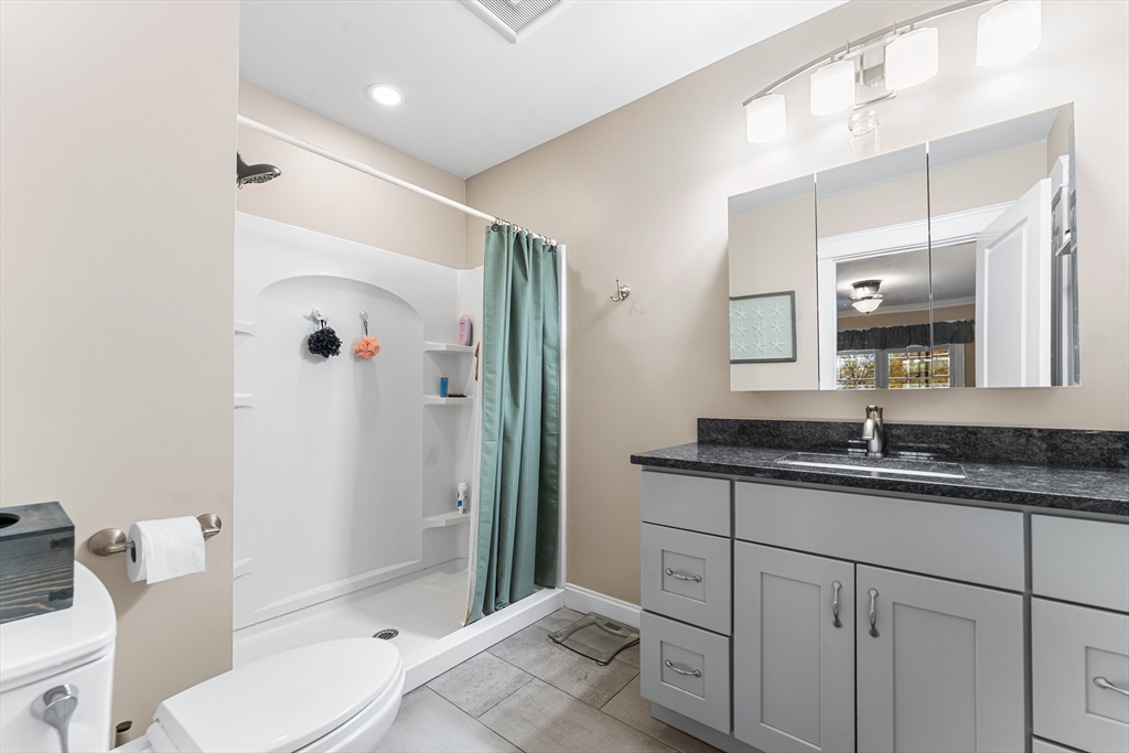 22 Washington Street Mendon, MA 01756 - Photo 14 of 31 a bathroom with a granite countertop sink a toilet a mirror and shower