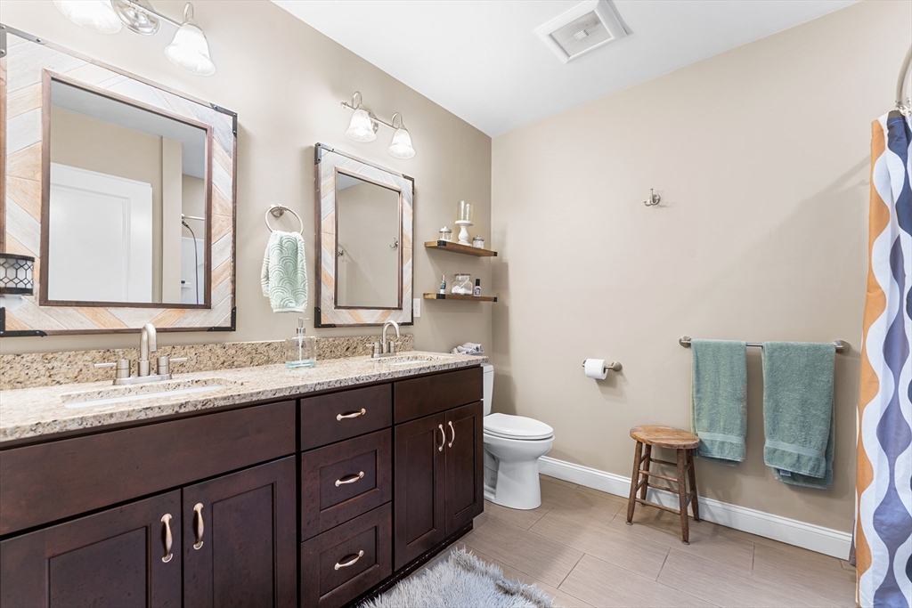 22 Washington Street Mendon, MA 01756 - Photo 20 of 31 a bathroom with a double vanity sink a toilet and a mirror