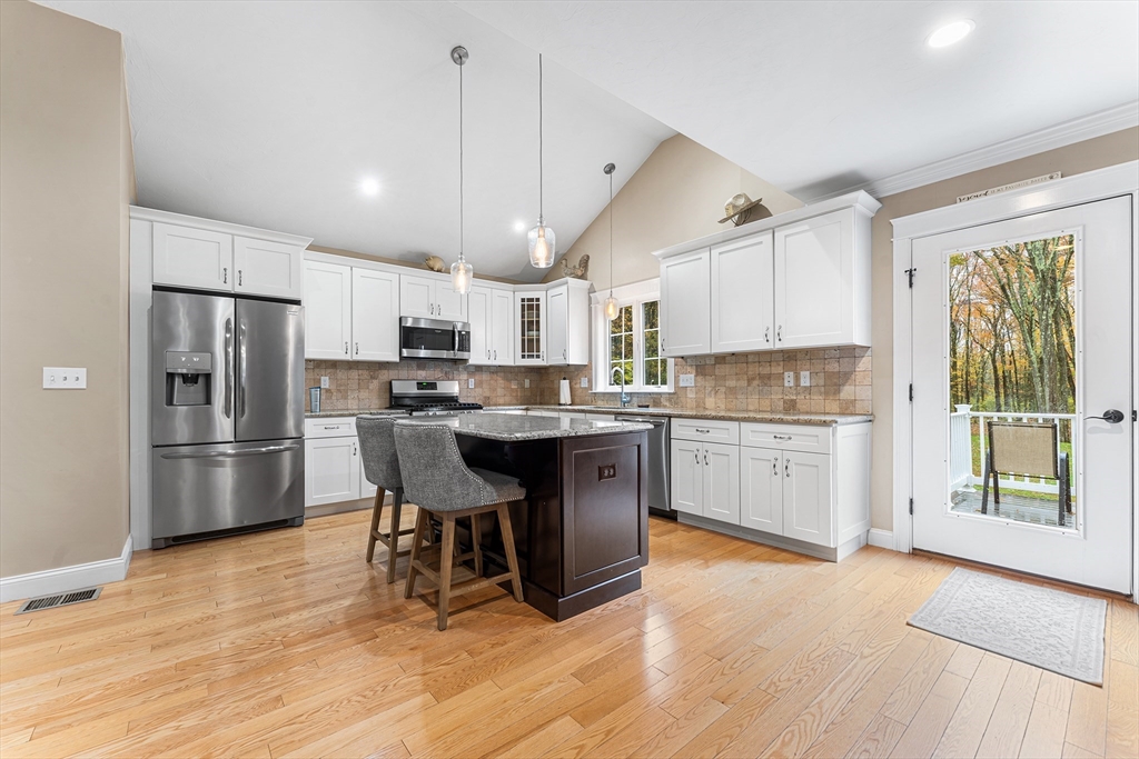 22 Washington Street Mendon, MA 01756 - Photo 6 of 31 a kitchen with stainless steel appliances a refrigerator a stove a sink dishwasher a oven with white cabinets and wooden floor