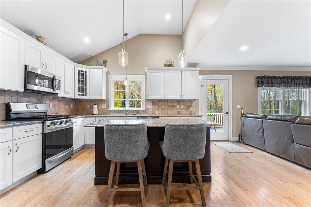 22 Washington Street Mendon, MA 01756 - Photo 8 of 31 a kitchen with stainless steel appliances granite countertop a kitchen island hardwood floor sink stove dining table and chairs