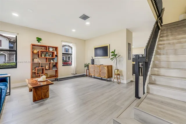 a view of a livingroom with furniture a flat screen tv and staircase