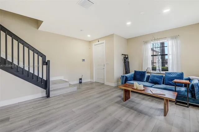 a living room with furniture and a wooden floor