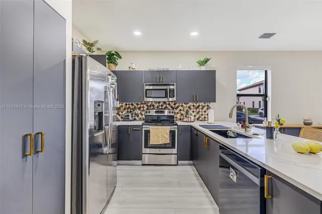 a kitchen with stainless steel appliances granite countertop a sink stove and refrigerator