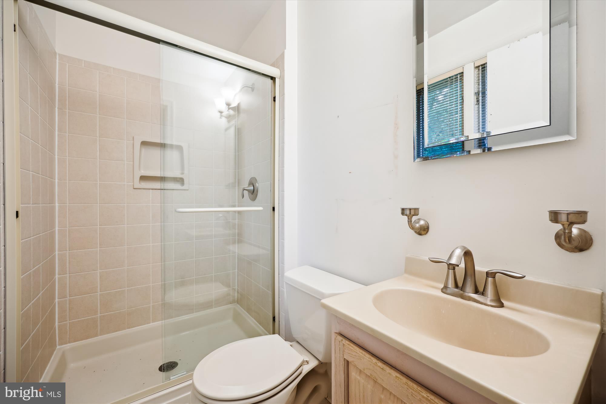 10205 Capitol View Avenue Silver Spring, MD 20910 - Photo 14 of 27 a bathroom with a sink toilet a mirror and shower