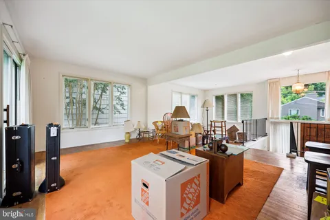 a living room with furniture a flat screen tv and a large window