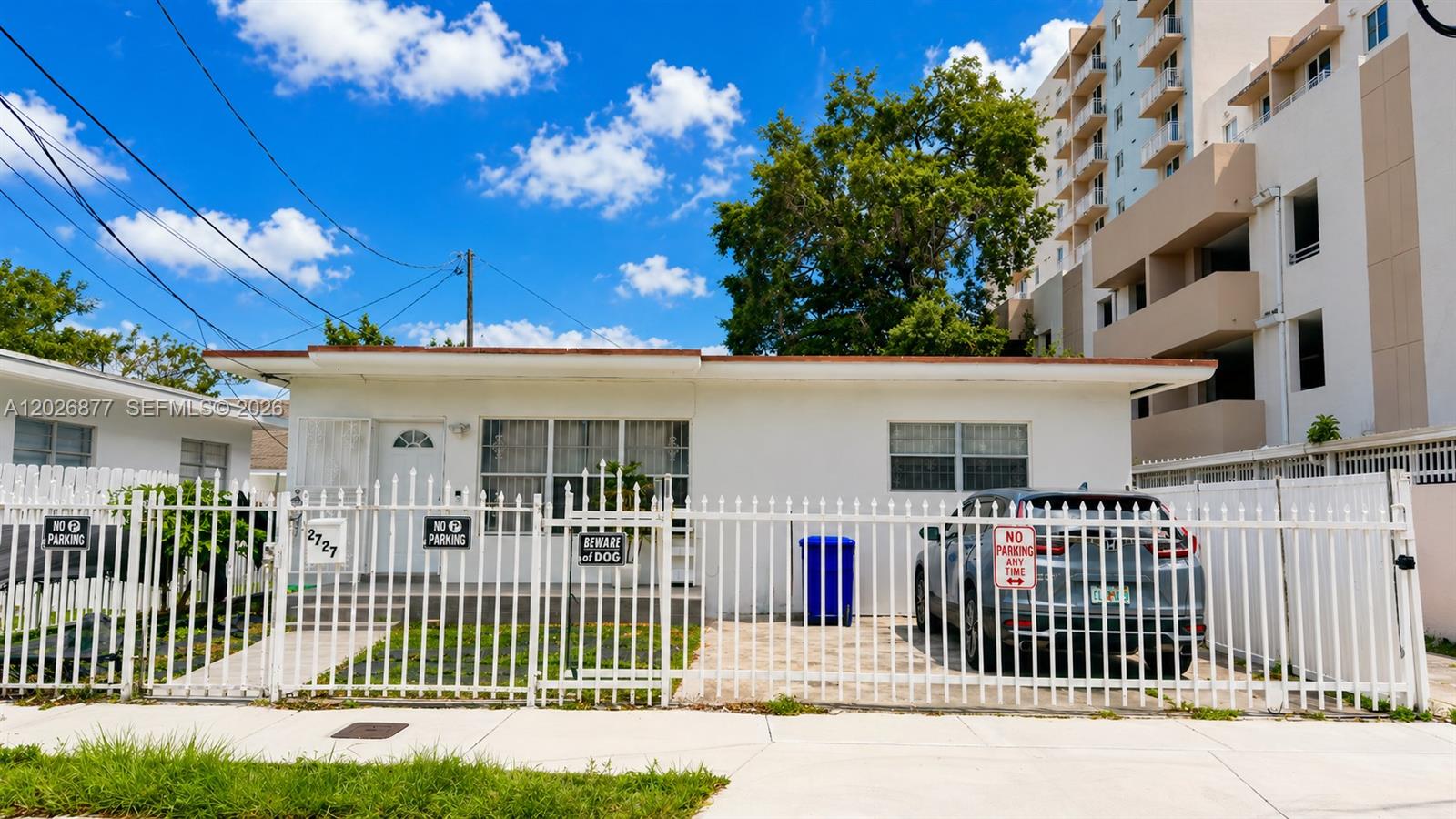 2727 Southwest 24th Street Miami, FL 33145 - Photo 2 of 18 a view of a house with a fence and a tree