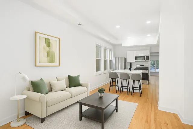 a living room with furniture and a dining table with wooden floor