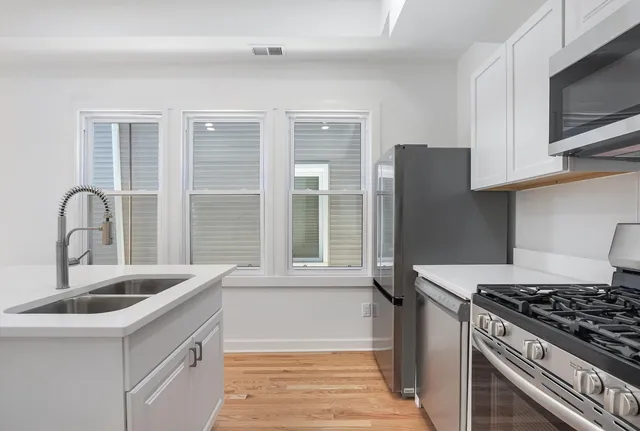 a kitchen with granite countertop a sink stainless steel appliances and cabinets
