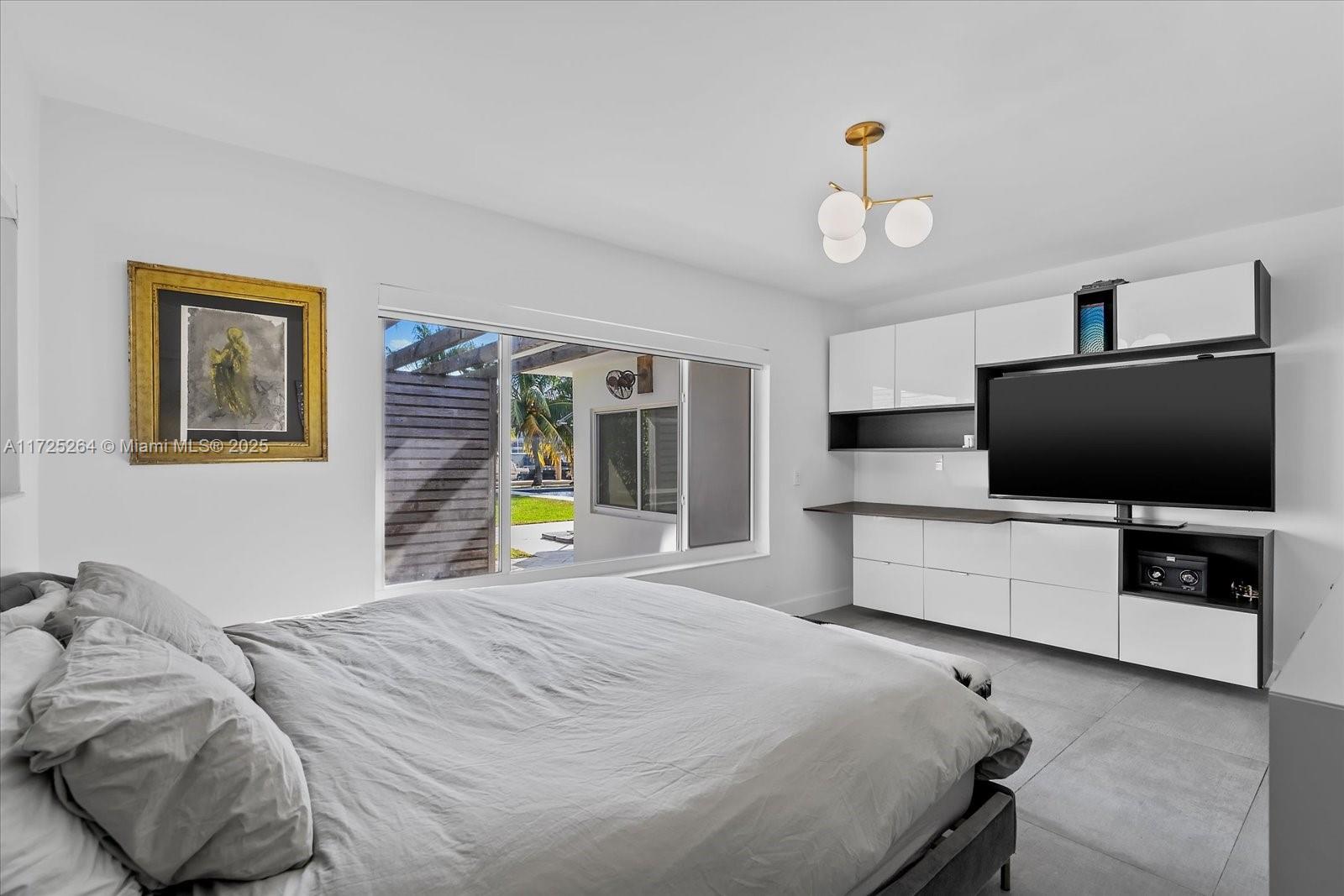 2104 Northeast 124th Street North Miami, FL 33181 - Photo 13 of 26 a bedroom with a bed and a flat screen tv