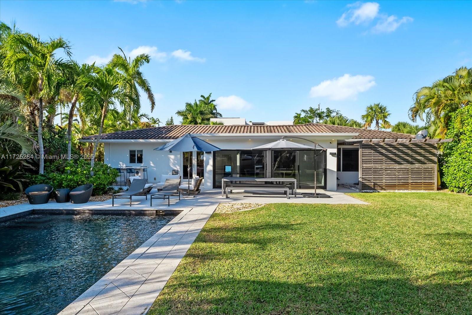2104 Northeast 124th Street North Miami, FL 33181 - Photo 16 of 26 a front view of a house with swimming pool having outdoor seating