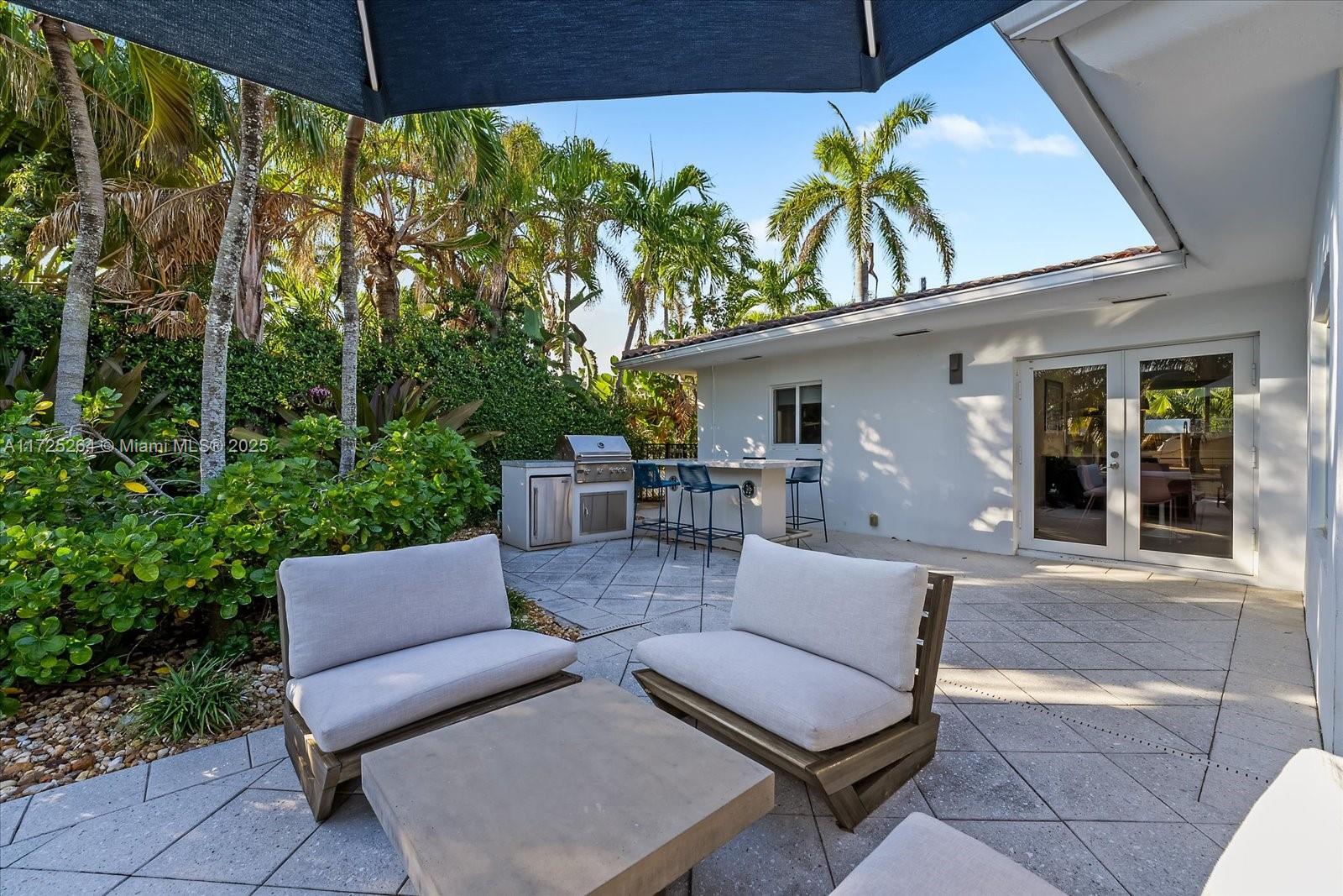 2104 Northeast 124th Street North Miami, FL 33181 - Photo 17 of 26 a view of a patio with couches table and chairs and potted plants