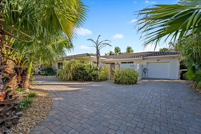 a view of a house with a yard and potted plants
