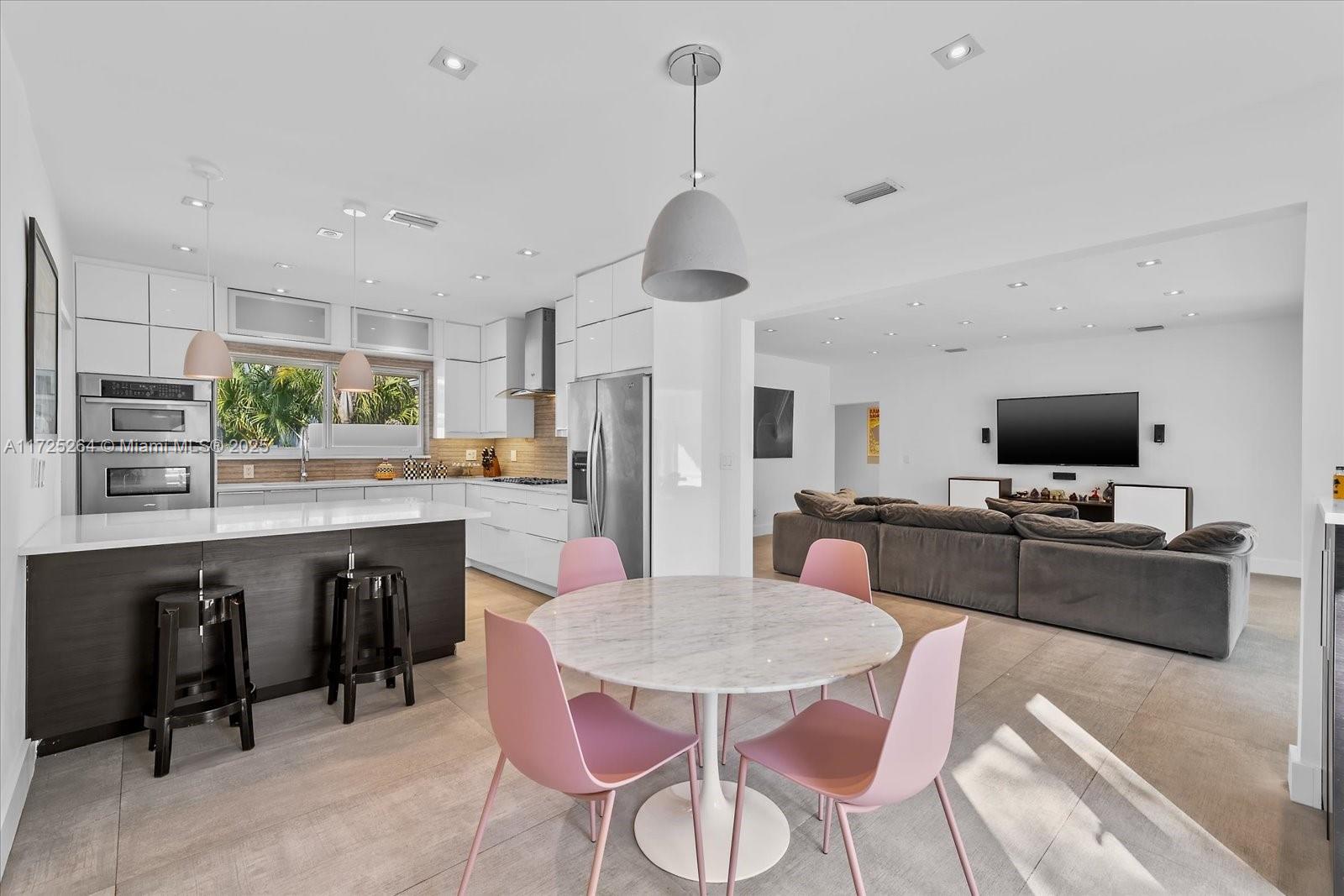 2104 Northeast 124th Street North Miami, FL 33181 - Photo 6 of 26 a kitchen with stainless steel appliances granite countertop a dining table chairs stove refrigerator and cabinets