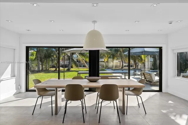 a view of a dining room with furniture large windows and wooden floor
