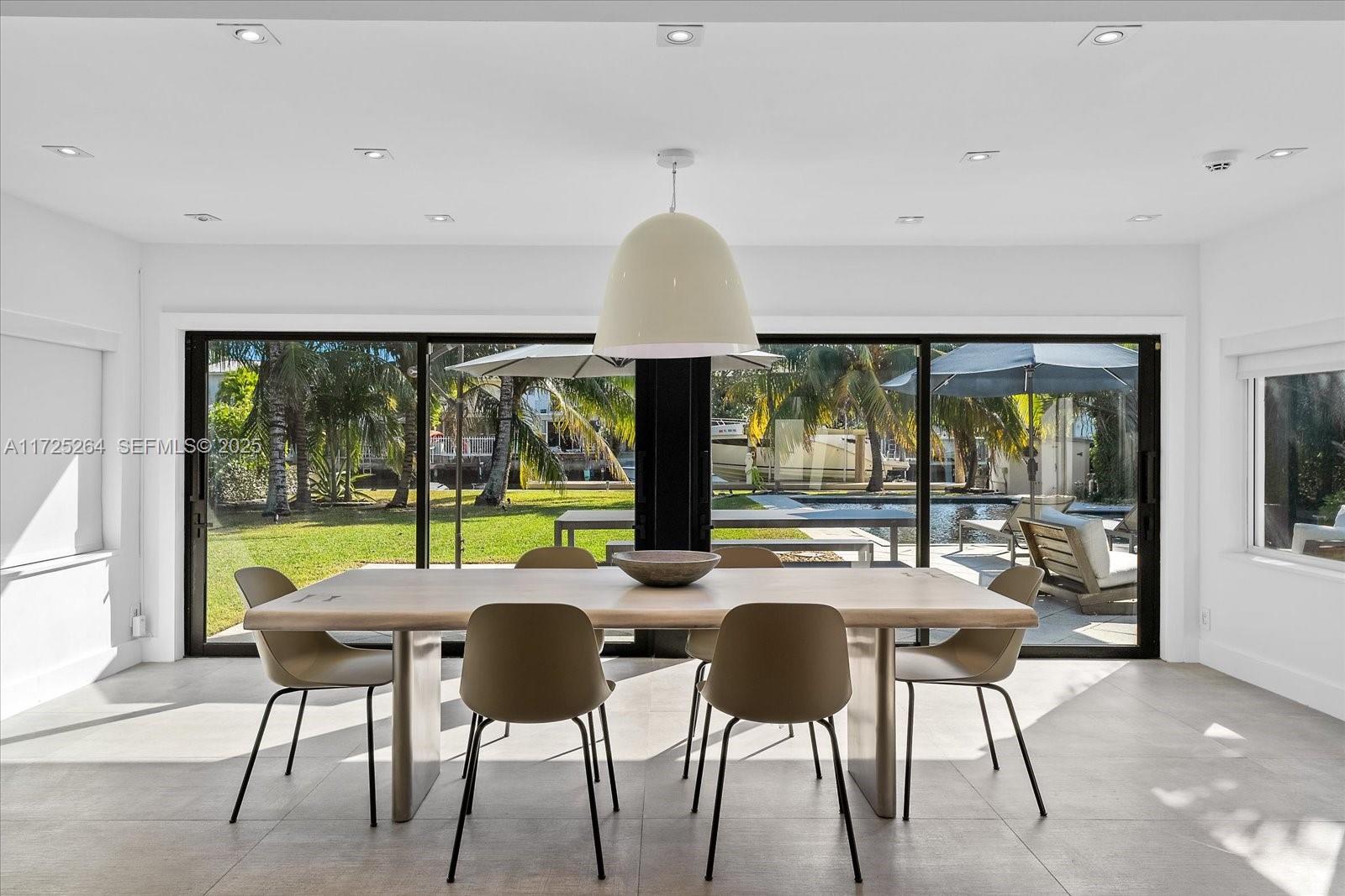 2104 Northeast 124th Street North Miami, FL 33181 - Photo 7 of 26 a view of a dining room with furniture large windows and wooden floor