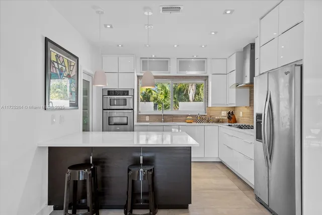 a kitchen with a sink stainless steel appliances and white cabinets