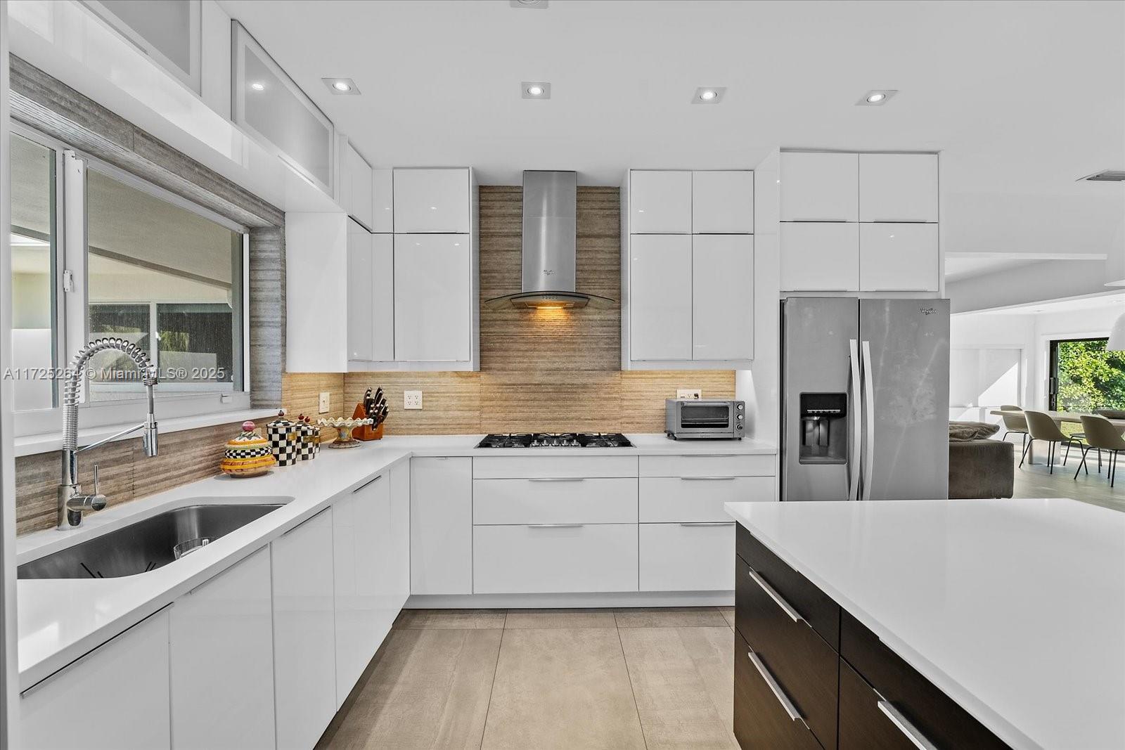 2104 Northeast 124th Street North Miami, FL 33181 - Photo 9 of 26 a kitchen with a sink stainless steel appliances and white cabinets