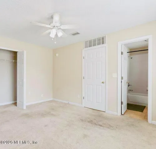 an empty room with fan and entrance