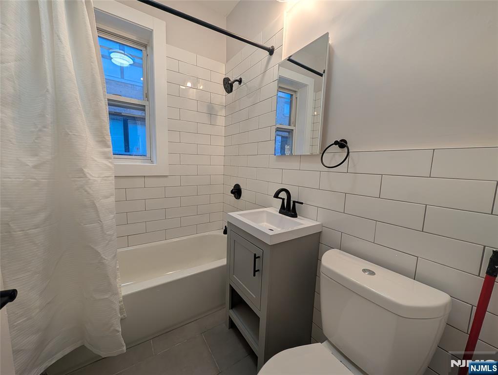 85 Anderson Street, Unit C6 Hackensack, NJ 07601 - Photo 8 of 10 a bathroom with a toilet and a bathtub