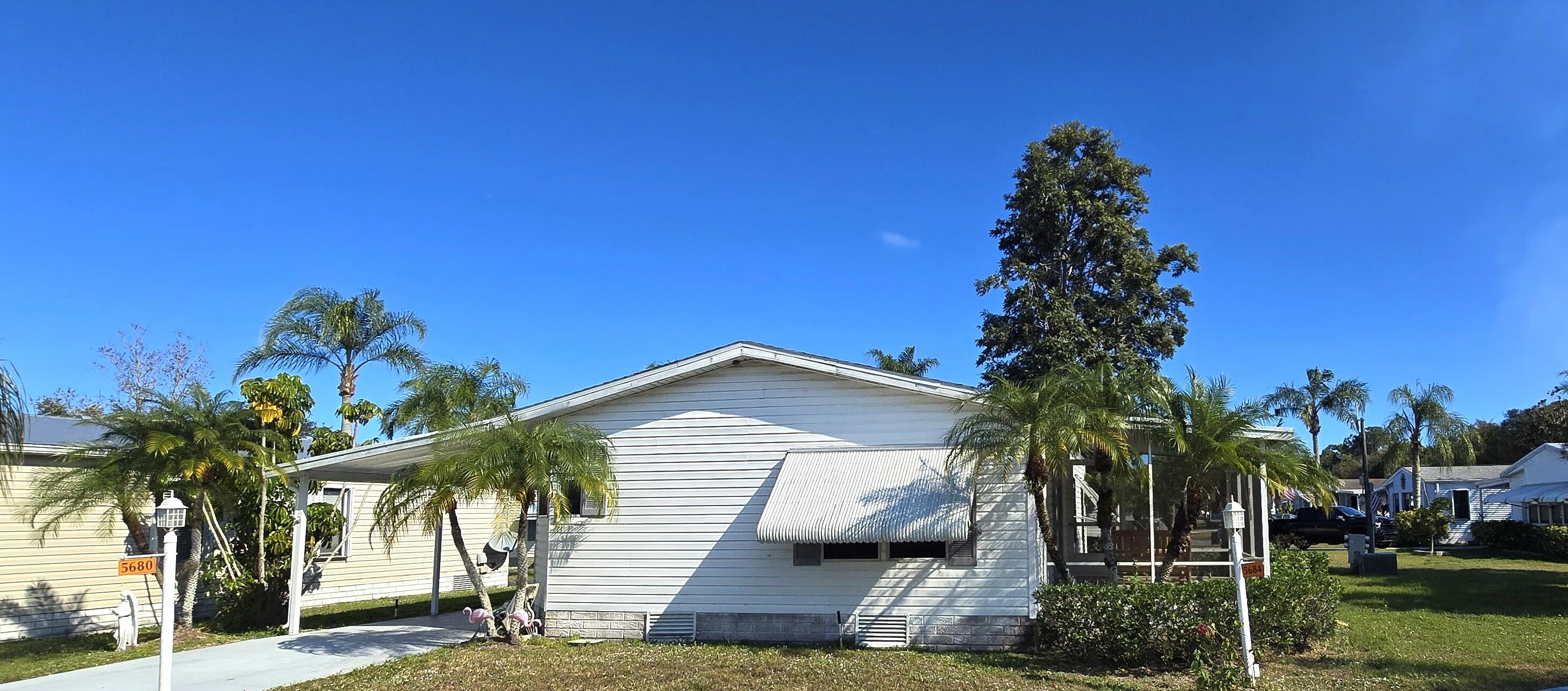 5680 Hemingway Court, Unit 15 Fort Pierce, FL 34982 - Photo 3 of 18 a view of a house with a tree and a yard