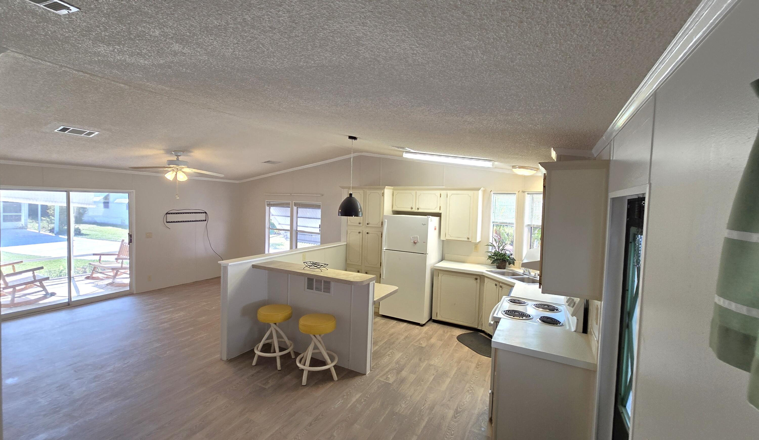 5680 Hemingway Court, Unit 15 Fort Pierce, FL 34982 - Photo 9 of 18 a view of a kitchen with furniture and wooden floor