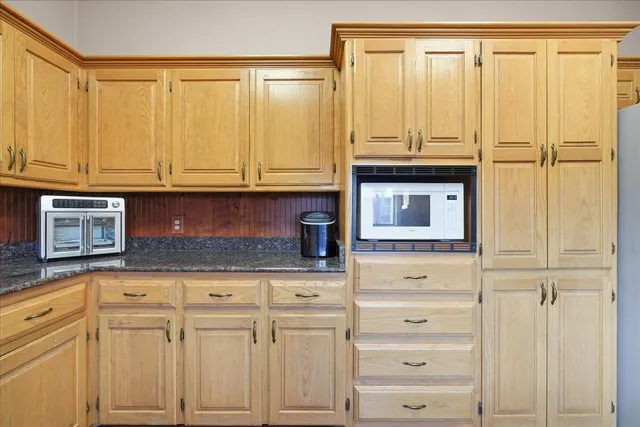 a kitchen with granite countertop white cabinets and stainless steel appliances