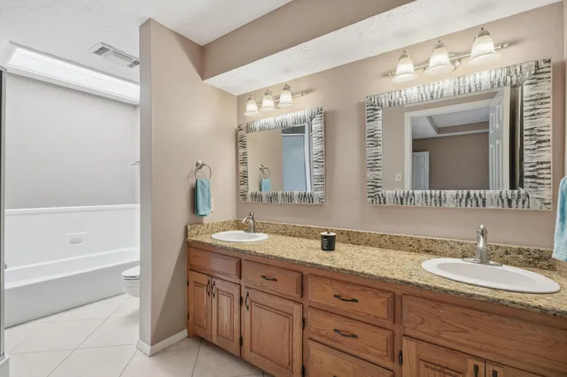 a bathroom with a granite countertop sink mirror and bathtub