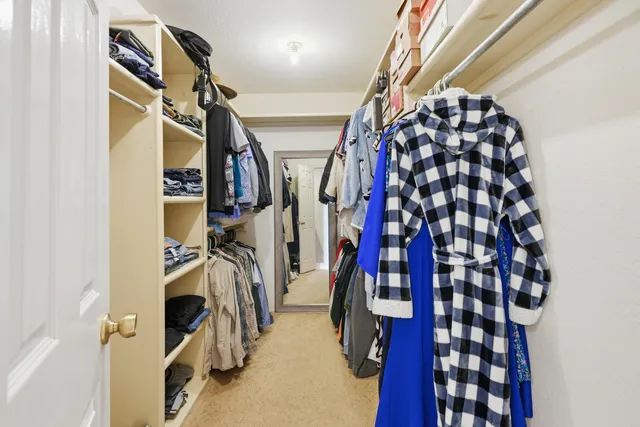 a view of walk in closet with clothes