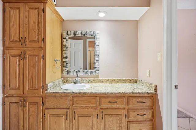 a bathroom with a granite countertop sink and a mirror