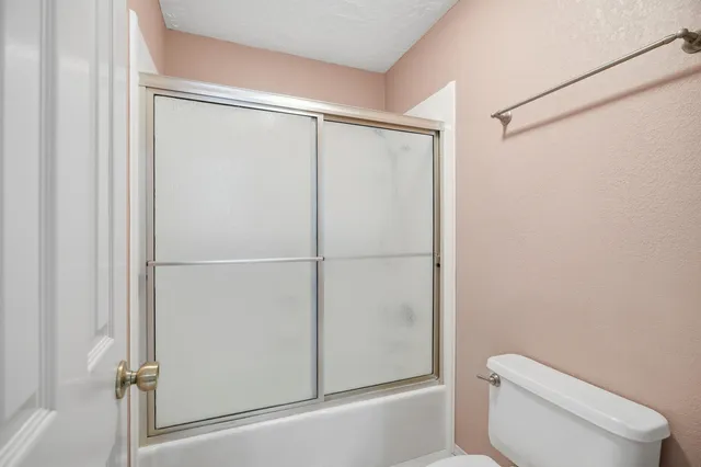 a white toilet sitting next to a shower