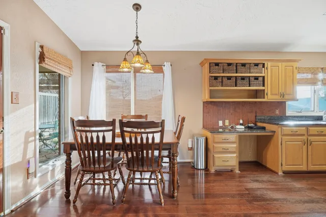a dining room with furniture a chandelier and wooden floor