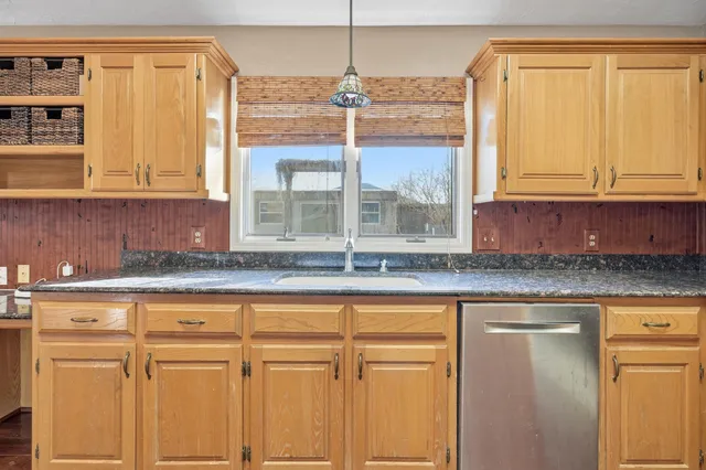a kitchen with granite countertop cabinets and window