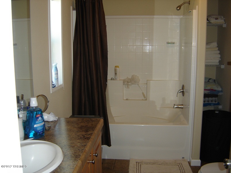 405 Schut Road Moxee, WA 98936 - Photo 9 of 11 a bathroom with a granite countertop sink a toilet and shower