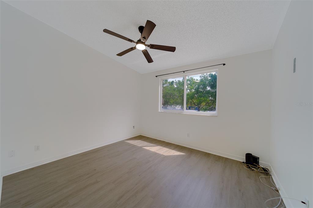 9241 Jake's Path Largo, FL 33771 - Photo 15 of 46 an empty room with a window and a ceiling fan
