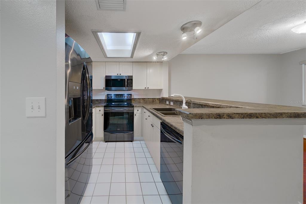 9241 Jake's Path Largo, FL 33771 - Photo 28 of 46 a kitchen with stainless steel appliances granite countertop a stove and a refrigerator