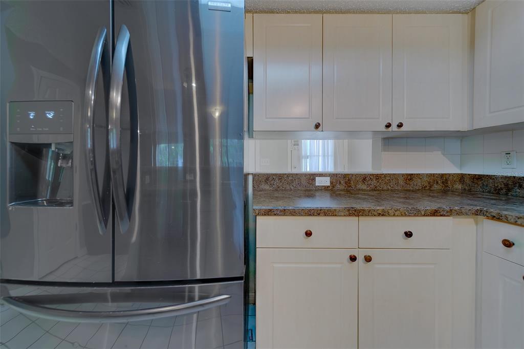 9241 Jake's Path Largo, FL 33771 - Photo 32 of 46 a view of a granite countertop white cabinets and a wooden floor