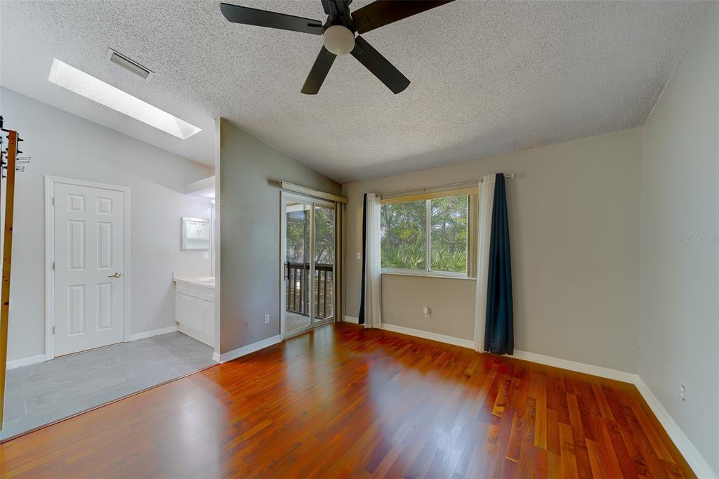 9241 Jake's Path Largo, FL 33771 - Photo 7 of 46 a view of an empty room with window and wooden floor