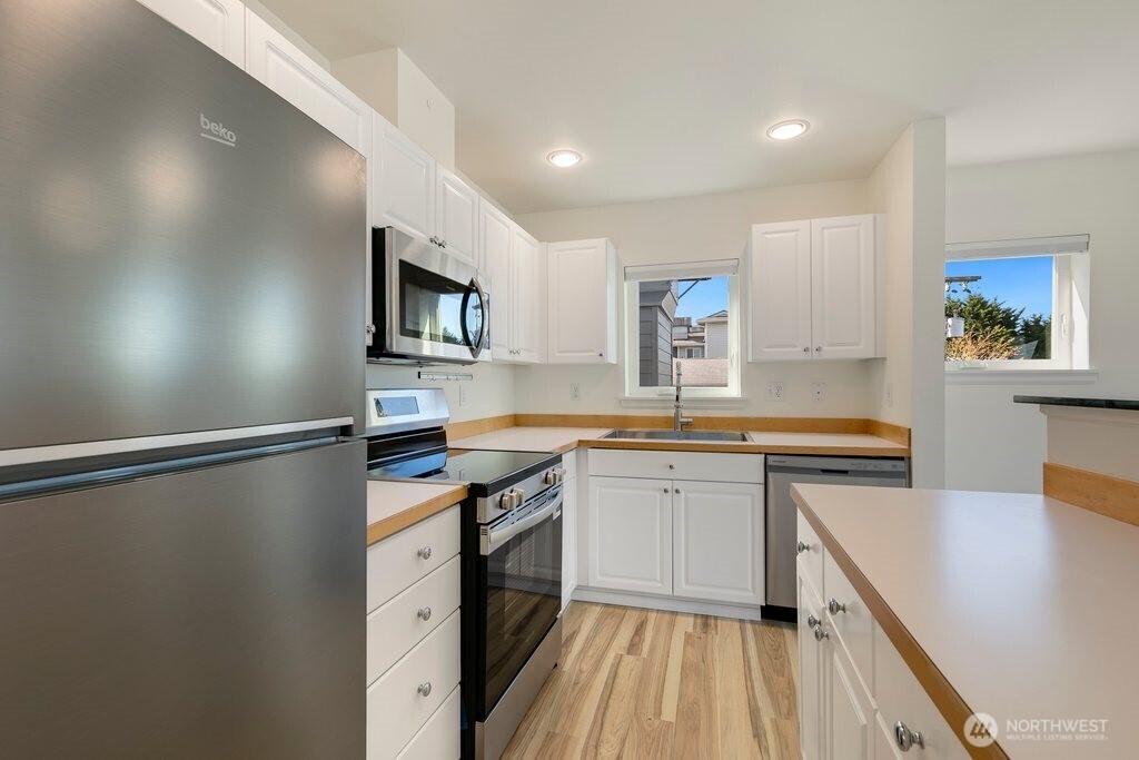 2101 North 55th Street, Unit 201 Seattle, WA 98103 - Photo 12 of 24 a kitchen with stainless steel appliances granite countertop a sink stove and refrigerator