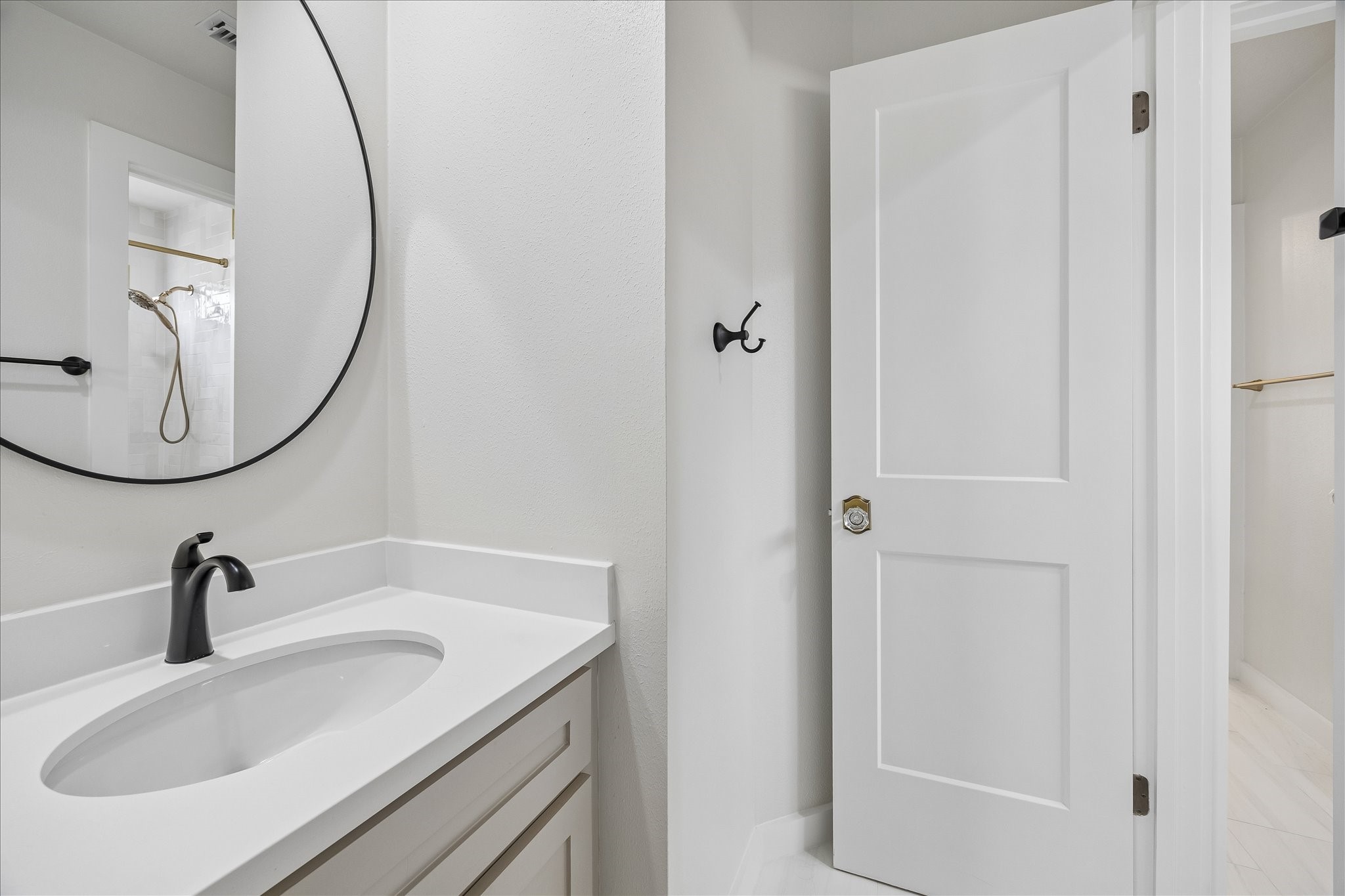 7915 Huddersfield Court Spring, TX 77379 - Photo 33 of 37 Updated Jack & Jill bath with clean modern finishes, black fixtures, a round mirror.