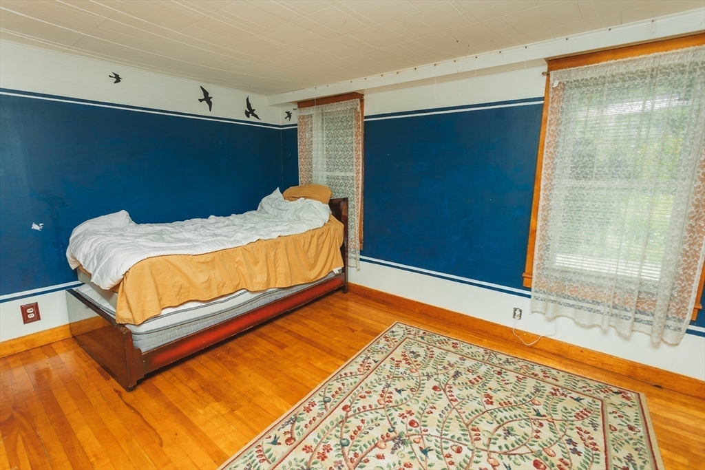 21 River Street Colrain, MA 01340 - Photo 20 of 28 a bed sitting in a bedroom next to a window and a wooden floor