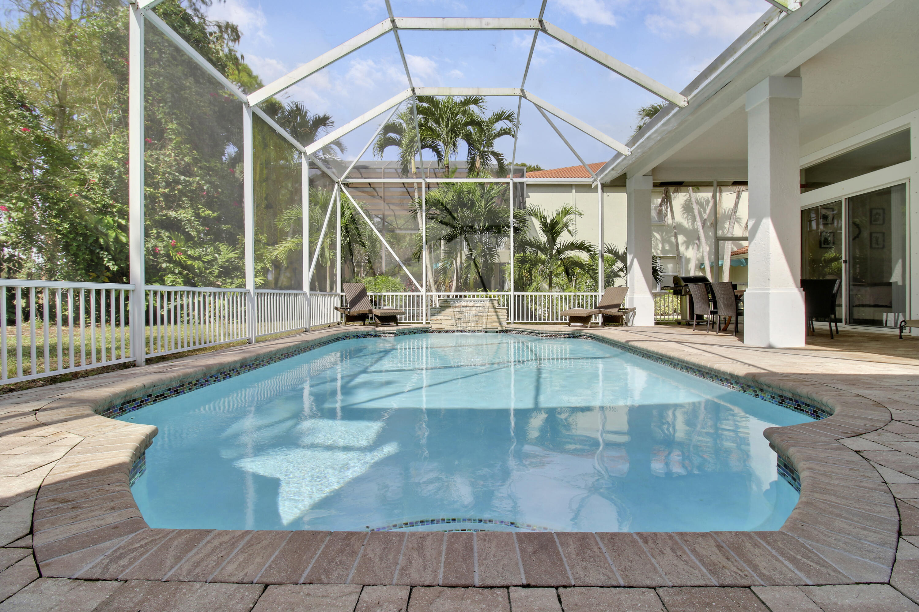 799 Cedar Cove Road Wellington, FL 33414 - Photo 33 of 44 a view of a patio with a table and chairs under an umbrella